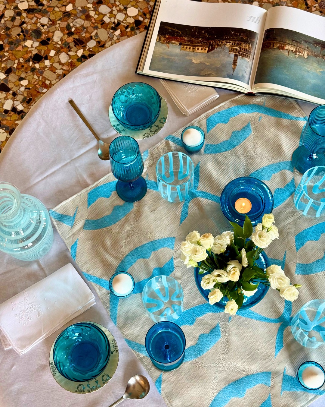 Una tavola veneziana per la Festa della Sensa, dove il turchese incontra il bianco in un gioco di luce e riflessi. Ispirata alla laguna e alla tradizione di Venezia, celebra il legame tra acqua e città con eleganza e leggerezza, tra vetro, trasparenze e atmosfera festosa.
A Venetian table for the Festa della Sensa, where turquoise meets white in a play of light and reflections. Inspired by the lagoon and Venice’s tradition, it celebrates the bond between water and city with elegance and lightness, through glass, transparency, and a festive atmosphere.
#FestaDellaSensa #Venezia #TableSetting #Turchese #MuranoGlass #VeniceStyle #Eleganza