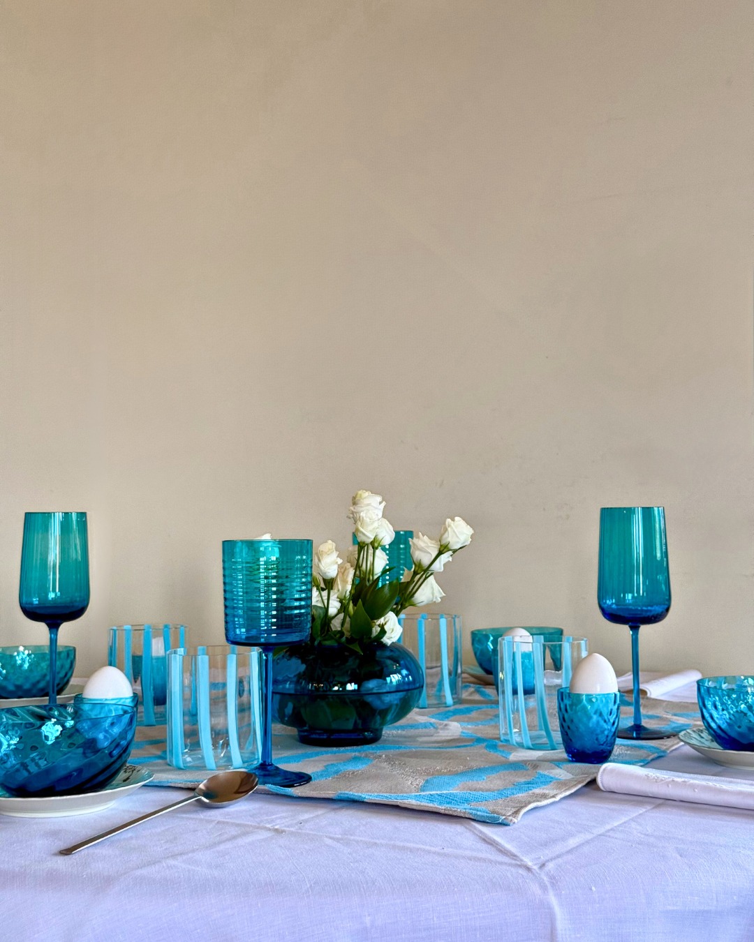 Turchese e bianco si incontrano in una tavola fresca e luminosa, ispirata alla leggerezza dell’acqua e alla purezza della luce. Contrasti delicati e riflessi trasparenti creano un’atmosfera elegante, perfetta per uno stile raffinato ma naturale.
Turquoise and white come together in a fresh, luminous table setting inspired by water and light. Soft contrasts and прозрачные reflections create an elegant atmosphere, perfect for a refined yet effortless style.
#TurcheseEBianco #TableSetting #MuranoGlass #Eleganza #Design #Style